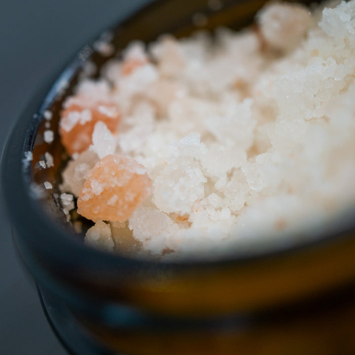 Opened jar of bath salts pink Himalayan and white salts from an angle