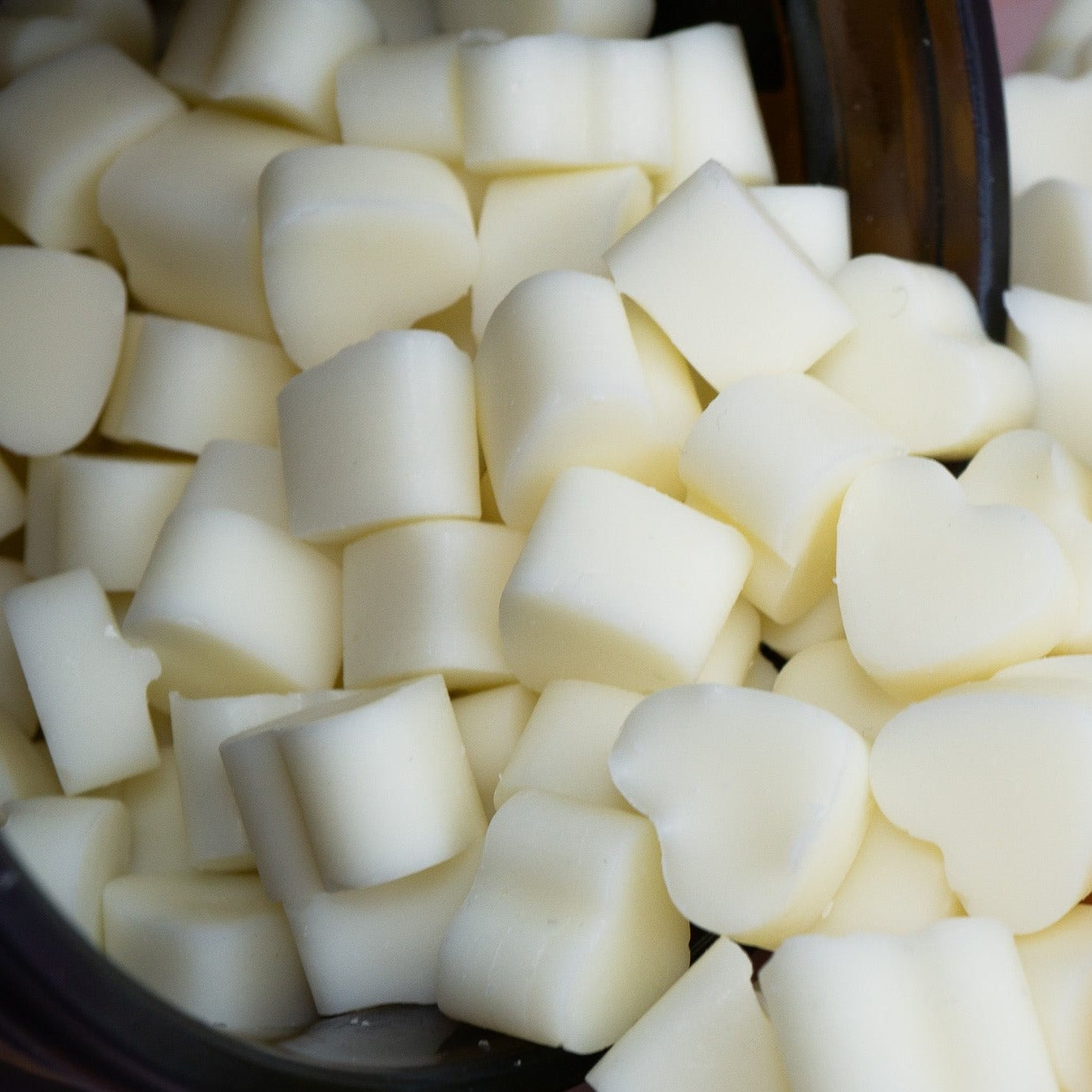 Creamy wax melts tumbling out of jar